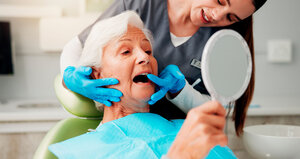 Zahnarzt, ältere Frau und Beratung mit Spiegel für Zahnreinigung, Zahnimplantat oder Mundhygiene.