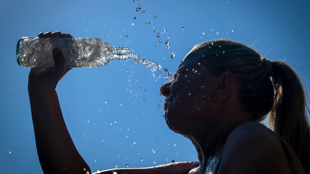 mis_020718_bf_36.JPG 24.06.2026, Sommerhitze in Deutschland, Mindelheim im Unterallgäu, eine Frau erfrischt sich mit einem schwall kaltem Wasser in ihr Gesicht. (Modelrelased)
