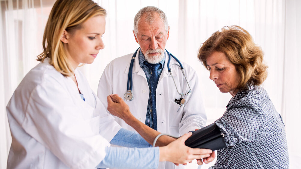 Arzt mit Patientin und MFA