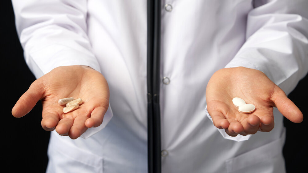 Cropped view of female Doctor holding in hands Pills to choose. Difficult Choice between drugs. Placebo drugs concept. Healthcare concept. Doctor Hands with Pills. Difficult Choice between drugs. Placebo drugs concept. Healthcare concept.