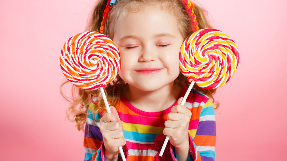 Studio portrait of a beautiful little girl with large Lollipop Mädchen mit Lollys