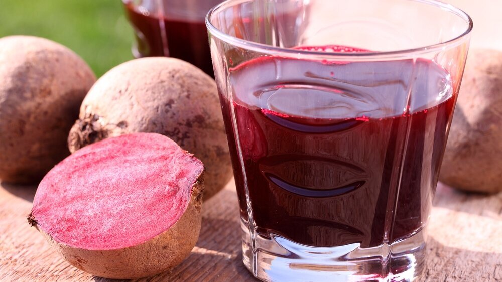 Glass with beetroot juice on garden table Rote-Bete-Saft im Glas