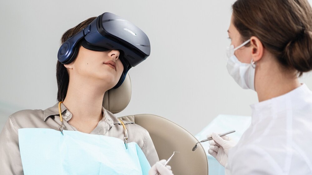 A dentist examines the teeth of her patient on the dentistry's chair, while the patient is wearing VR glasses Patientin mit VR-Brille beim Zahnarzt