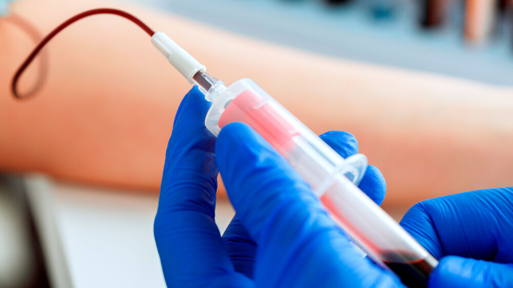Hands of a doctor taking blood samples using a tube holder Blutabnahme